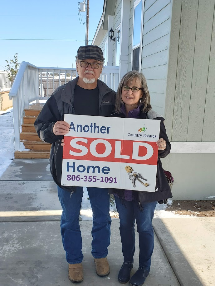 New Homeowners with Sold Sign at Country Estates